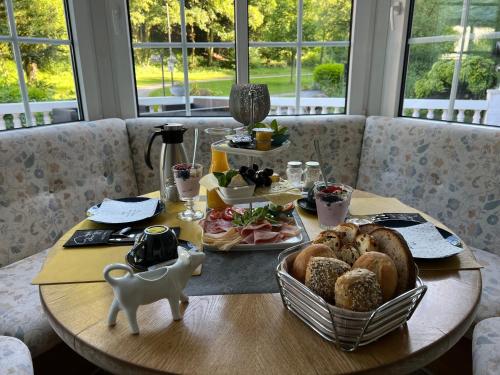 a table with a plate of bread and a basket of food at Health and Spa by Doro im Hotel am Schwanenweiher in Bad Bertrich