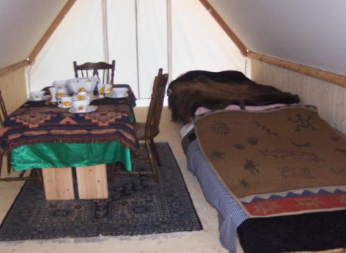 Cette chambre comprend deux lits, une table et des chaises. dans l'établissement La Cabane du Trappeur V d N, à Voellerdingen