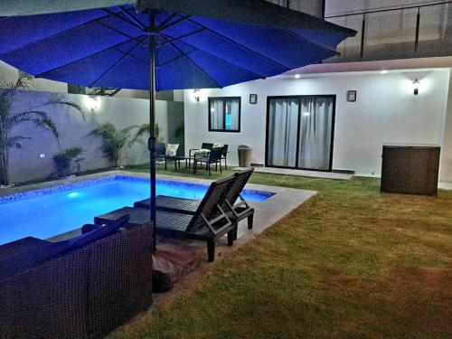 a house with a pool with a blue umbrella at Ark Villa in Punta Cana