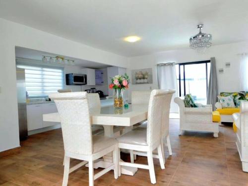a kitchen and dining room with a white table and chairs at Ark Villa in Punta Cana