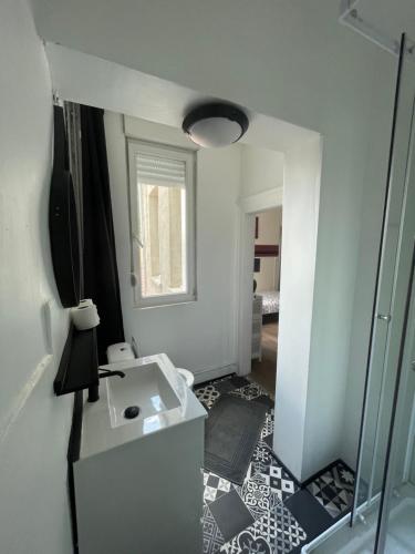 y baño con lavabo blanco y espejo. en La clef Sithieu, en Saint-Omer