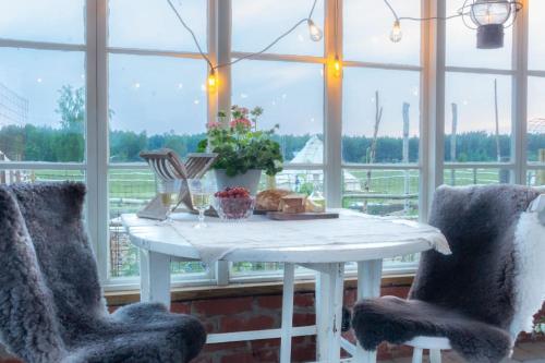 a white table and two chairs in a room with a window at FARM LIVING in Gottby