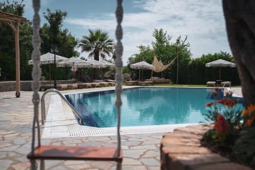 a swimming pool with chairs and umbrellas at Panorama Hideaway in Dassia