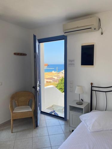 sypialnia z łóżkiem i widokiem na ocean w obiekcie Captain's Nest w mieście Andros