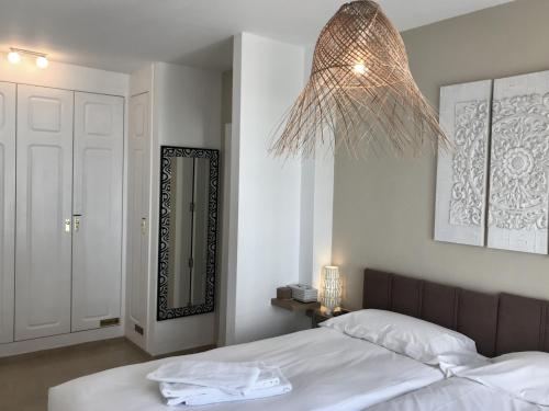 馬尼爾瓦的住宿－2204-Luxury apt on the beach,new,on duquesa port!，一间卧室配有一张床和一个吊灯