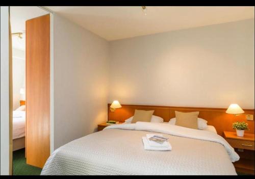 布蘭肯貝赫的住宿－Golfsuite 13，一间卧室配有一张带两盏灯的大型白色床。