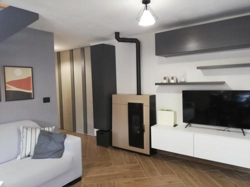 uma sala de estar com um sofá branco e uma televisão de ecrã plano em Bardonecchia Apartment em Bardonecchia