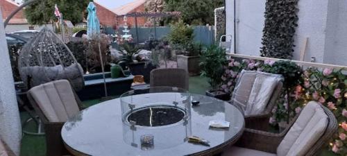 a patio with a table and chairs and flowers at The Vale Apart Hotel in Hull
