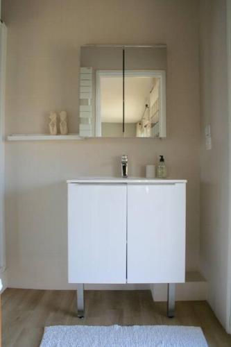 une salle de bain blanche avec un lavabo et un miroir dans l'établissement Amazing Sea view, à Antibes