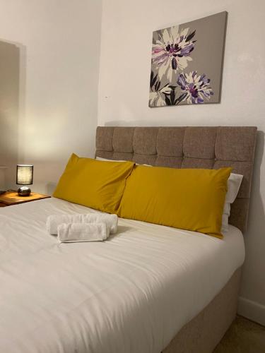 a bedroom with a bed with yellow pillows at Bittern Lodge Homestay with Free Parking & Parking for cruise available, Full access to kitchen in Southampton in Southampton