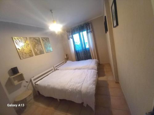 - une petite chambre avec un lit blanc et une fenêtre dans l'établissement Charmante maison proche Aix en pce - Spa, à Ventabren