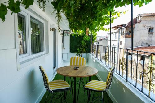 a porch with a table and chairs on a balcony at Taksim Neo Pera Suites in Istanbul