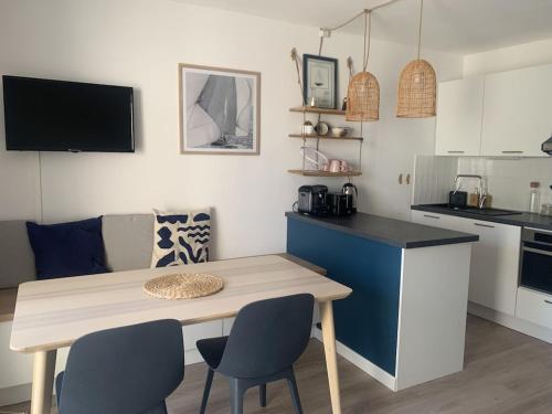 une cuisine avec une table et des chaises dans une pièce dans l'établissement Les Haubans * Moderne * Calme * Wifi, à La Trinité-sur-Mer