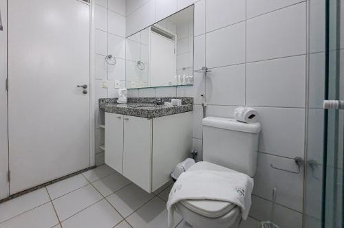 a white bathroom with a toilet and a sink at Paraíso das Dunas Pé na Areia 2 Suítes 6 Pessoas in Aquiraz