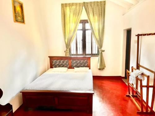 Schlafzimmer mit einem Bett und einem Fenster in der Unterkunft Sadamadala Guest House Kandy in Kandy