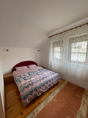 a bedroom with a bed and two windows at Mariner House in Plav