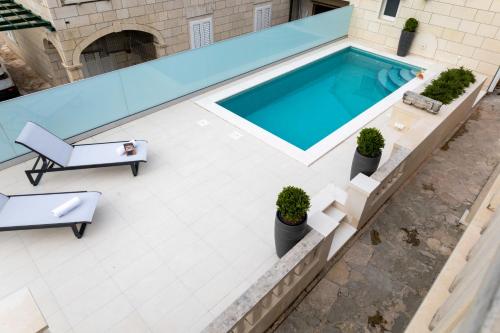 an overhead view of a swimming pool with a table and a chair at Insula Apartment with Private Pool in Pučišća