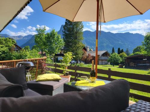 a patio with two couches and an umbrella at Alpenblick in Oberammergau