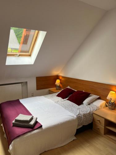 a bedroom with a bed with red pillows and a window at Willa Krystyna in Krynica Zdrój