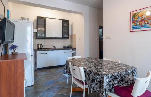 a kitchen and dining room with a table and chairs at Apartments Corny in Pag