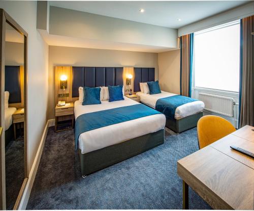 a hotel room with two beds and a desk at Dover Marina Hotel & Spa, Tapestry Collection by Hilton in Dover