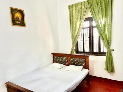 Bett in einem Zimmer mit Fenster in der Unterkunft Sadamadala Guest House Kandy in Kandy