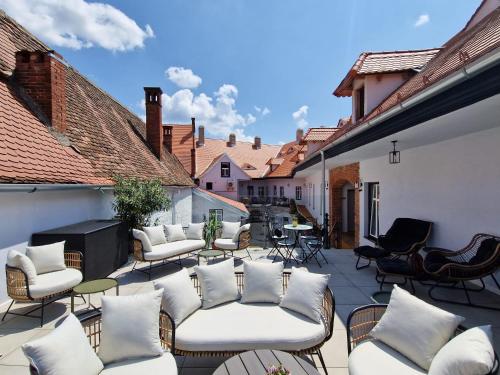 a patio with couches and chairs on a balcony at MAGISTER seven in Sibiu