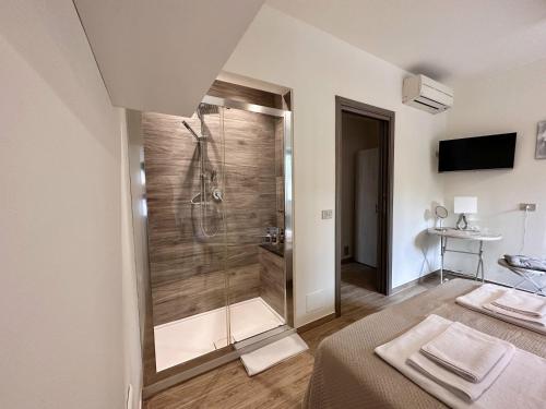 La salle de bains est pourvue d'une douche avec une porte en verre. dans l'établissement Amuka B&B, à Santo Stefano di Camastra