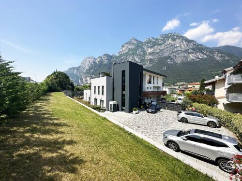 a car parked in a parking lot with mountains in the background at Residence Zangirolami - Luxury Garden and Balcony Apartments in Riva del Garda