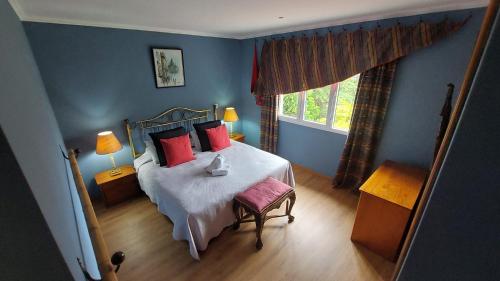 Schlafzimmer mit einem Bett mit roten Kissen und einem Fenster in der Unterkunft Pool Villa with Botanical Garden in São Gonçalo