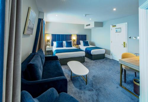 a hotel room with two beds and a couch at Dover Marina Hotel & Spa, Tapestry Collection by Hilton in Dover