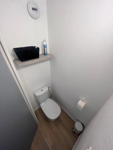 Elle comprend une petite salle de bains pourvue de toilettes et d'une étagère. dans l'établissement Appartement 5 personnes Sète, à Sète