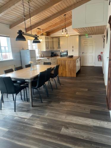a kitchen and dining room with a table and chairs at Margrétarhof in Hella