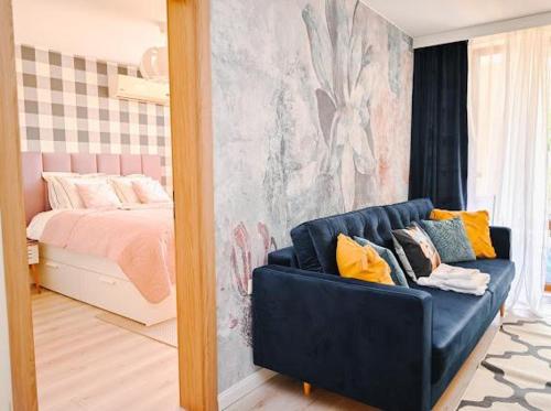 um quarto com um sofá azul em frente a uma cama em Sea Viev apartments in Sea Fort Club Grand Resort em Elenite