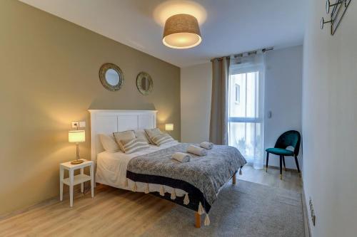 ein Schlafzimmer mit einem Bett, einem Stuhl und einem Fenster in der Unterkunft OVELIA Dijon - Le Courtille Ste-Marthe in Dijon