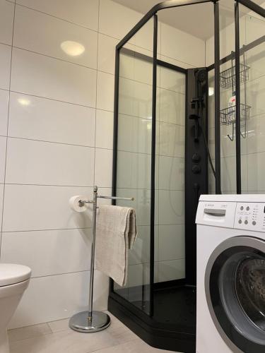 a bathroom with a washing machine and a washer at Leilighet ved sjøen med strand in Porsgrunn