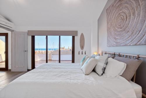 a white bedroom with a large bed with white pillows at Blue Greenwich Port in Altea
