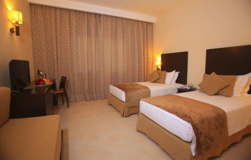 a hotel room with two beds and a television at Labranda Targa Aqua Parc in Marrakech