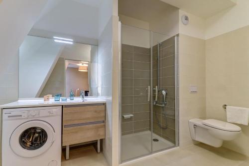ein Bad mit einer Dusche und einer Waschmaschine in der Unterkunft OVELIA Dijon - Le Courtille Ste-Marthe in Dijon