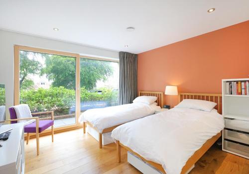 sypialnia z 2 łóżkami i dużym oknem w obiekcie Kingswood w Edynburgu
