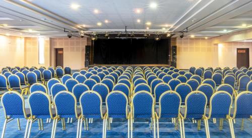 a lecture hall with blue chairs and a screen at Labranda Targa Aqua Parc in Marrakech