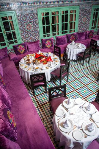 a dining room with two tables and purple furniture at Rose Aqua Park Hotel in Marrakesh