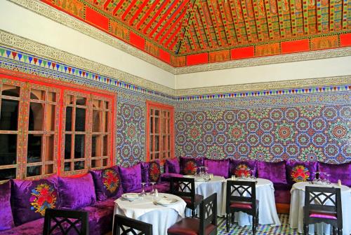a dining room with purple chairs and tables at Rose Aqua Park Hotel in Marrakesh