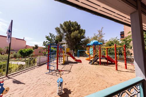 a playground in the sand with slides and swings at Rose Aqua Park Hotel in Marrakesh
