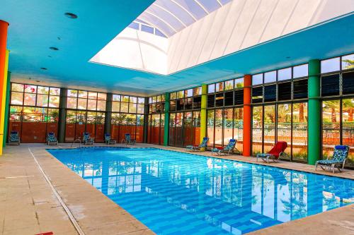 a large swimming pool with chairs in a building at Rose Aqua Park Hotel in Marrakesh