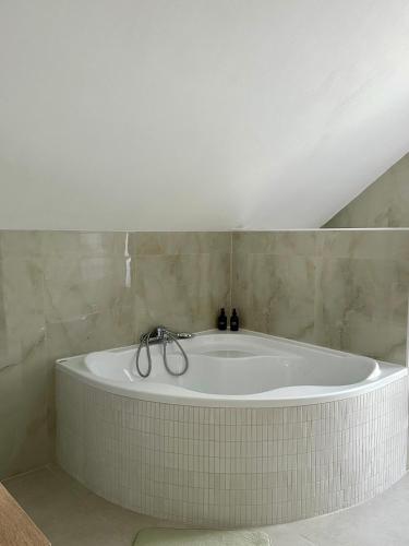 a bath tub in a bathroom with a ceiling at Penzion MOVEINN in Prague