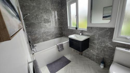 La salle de bains est pourvue d'un lavabo, d'une baignoire et de toilettes. dans l'établissement Contemporary beach apartment, à Brighton et Hove