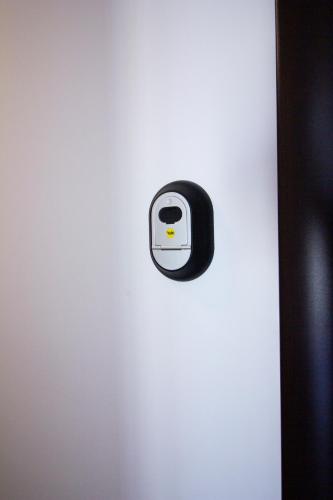 a black and white button on the side of a refrigerator at 3 Rooms A502 StayInn by Cosmopolis in Bucharest