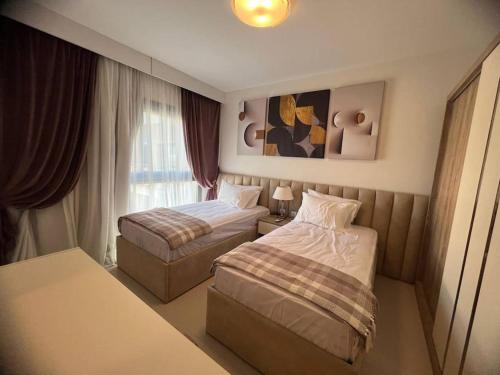 a hotel room with two beds and a table at MKD Marina Residence in El Alamein