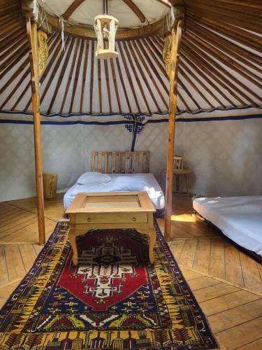 - une chambre avec un lit et une table dans une yourte dans l'établissement L'alternatif, à Huriel
